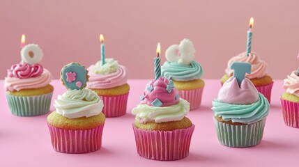 A festive birthday display of cupcakes with unique designs set against a pastel background