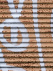 Orange roller blind wounded by white grafitti