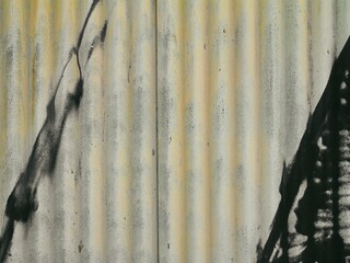 Dirty old corrugated iron painted with weak yellow hints and black strokes