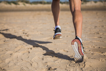 Muscular man running on the beach along the shoreline