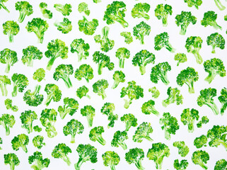 Numerous green broccoli illustrations are arranged uniformly on a white background, highlighting the intricate details of each piece, creating a lively and fresh aesthetic suitable for culinary themes