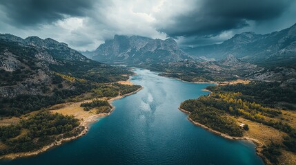 Stunning aerial view of rugged mountain peaks intersected by a glistening blue lagoon under dramatic storm clouds. Vibrant colors highlight breathtaking natural scenery and dynamic climate phenomena.