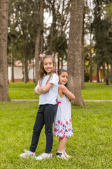 Fototapeta premium Two young girls are standing in a grassy field