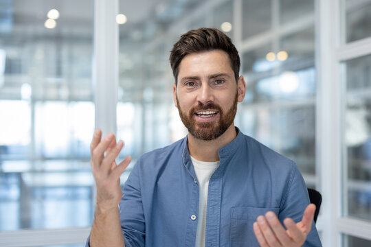 Webcam view, man talking looking into camera close up. Businessman at workplace using laptop for video call, smiling at online business meeting conference.