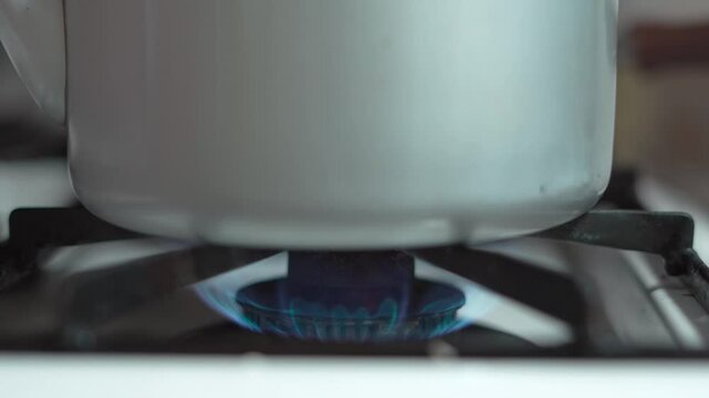 キッチンでヤカンが置かれたコンロに火を点ける