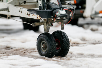 Industrial trailer lift tires close up on snow covered road in cold and slippery road winter