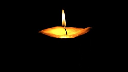 Burning candle isolated on a black background. Closeup flame burning in candle isolated on dark background. Candle fire flame