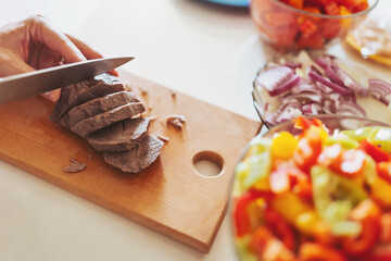 Chef at the pan with roasted meat and vetables. Preparing meal, meat and vegetables. man cutting...