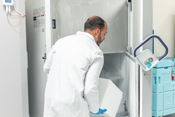 Scientist storing samples in cryogenic freezer in laboratory