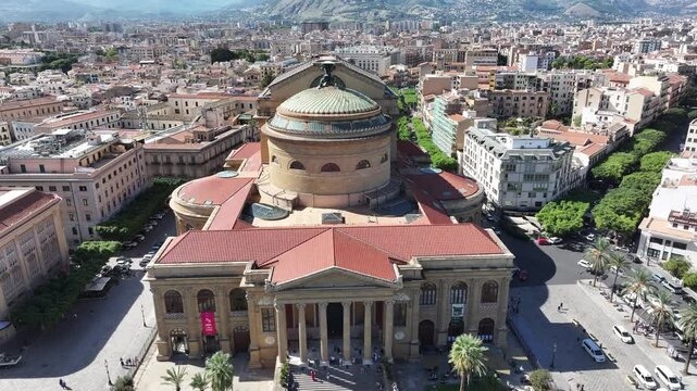 A stunning view of Teatro Massimo in Palermo, Italy, the third-largest opera house in Europe. The iconic structure stands out with its neoclassical architecture, surrounded by bustling streets.