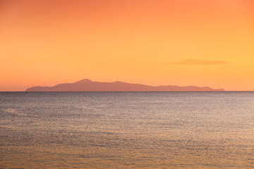 Wind turbines sunset. Seaside landscape with a wind turbine farm on a mountain. Green energy electricity source. Concept image for eco energy.