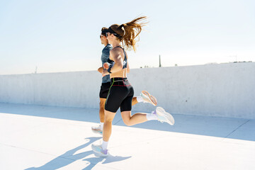 Couple running together on a sunny day in an urban environment for fitness and health