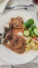 Plate of roasted chicken, potatoes, and cucumber slices enjoyed in marsa alam, egypt