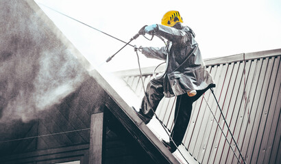 Washing the roof with a high-pressure washer.