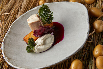 Salmon fillet with tartar sauce, herbs and crackers on a white plate.