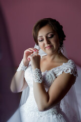 Obraz premium A woman in a wedding dress is wearing a white veil and a ring on her finger. She is looking at the camera with a smile on her face