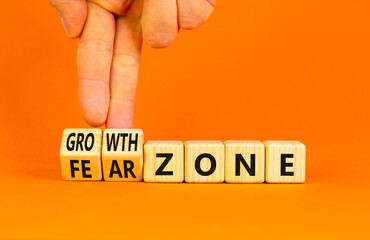 Growth or fear zone symbol. Concept words Growth zone Fear zone on wooden cubes. Beautiful orange table orange background. Psychologist hand. Business and growth or fear zone concept. Copy space.