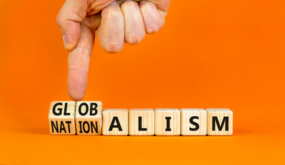 Globalism or nationalism symbol. Concept words Globalism or Nationalism on beautiful wooden blocks. Beautiful orange background. Businessman hand. Business globalism or nationalism concept. Copy space