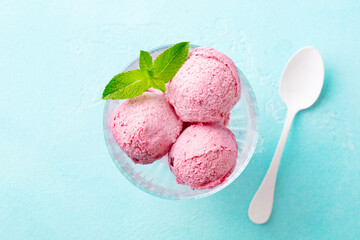 Strawberry Ice Cream in a glass bowl on blue background. Close up. Top view.