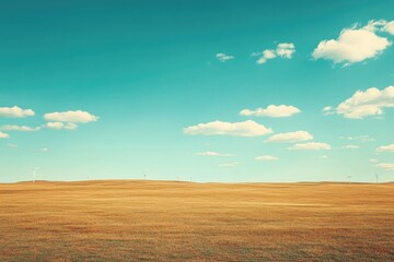 Serene landscape photo of a vast golden field under a vibrant blue sky dotted with fluffy white clouds; distant wind turbines add a touch of modern technology.
