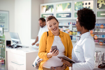 Pregnant woman talking to pharmacist in pharmacy