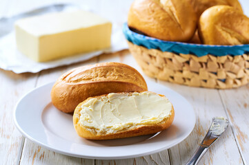 spreading butter on french bread or traditional Brazilian bread.