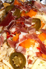 Loaded Nachos before being Cooked with Ham Cheese Jalapenos and Peppers