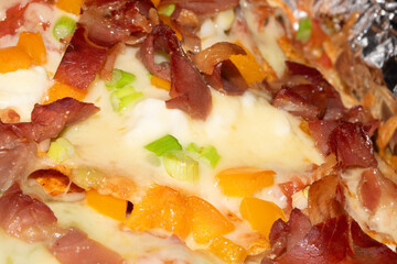 Loaded Nachos Close Up with Cured Ham Melted Cheese Jalapenos and Peppers Pizza Style