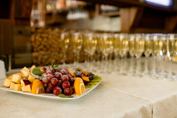 A row of glasses filled with champagne are lined up ready to be served.