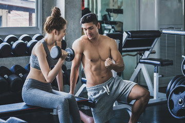 Naklejka premium Healthy wellness lifestyle concept of Happy asian couple fitness man and woman training exercise and dumbbell weight in sport gym