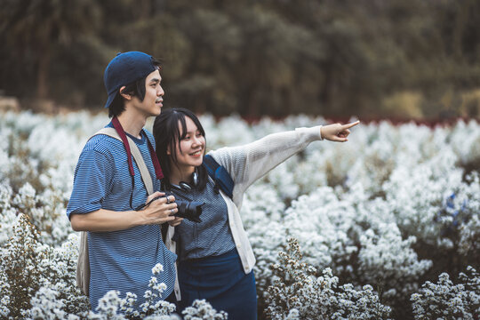 Romantic asian love couple traveler travel in white flower garden at Thailand Valentine day tourism concept