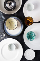 Top view of an empty plates, bowls and glasses placed on a black chalkboard background. Flat lay. Top view. Food concept.