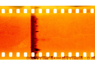 Dusty and grungy 35mm film texture or surface. Perforated scratched camera film isolated on white...