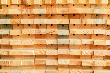 A close-up view of neatly stacked wooden blocks, showcasing their warm hues and distinct grain patterns. The texture and arrangement highlight the natural beauty of woodwork.