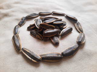 Minimalist composition featuring sunflower seeds on a white cloth background