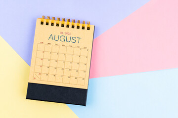 August 2025 desk calendar from brown paper on colorful background.