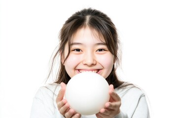 A young girl holds a white ball in her hands
