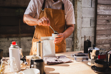  barista scooping freshly ground coffee into portable grinder, preparing for homemade brew. aroma...