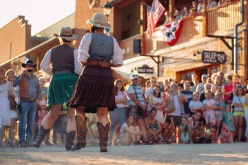 Two women in traditional American costumes dance country, wild west town. Zory, Silesia, Poland, 04.07.2017