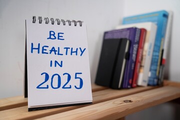  otwarty notes na półce z kartką na której widnieje tekst: Be healthy in 2025 © siwyk
