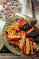 Sweet cookies with nuts and cakes with chocolate on a ceramic plate. Top view