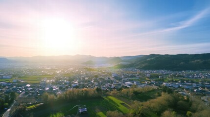 Sunlit Townscape: A breathtaking aerial view of a picturesque town nestled amidst rolling hills, bathed in the warm glow of a setting sun.