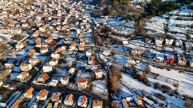 Drone view of snow covering the houses of Sapareva Banya Town on a sunny winter day in Bulgaria