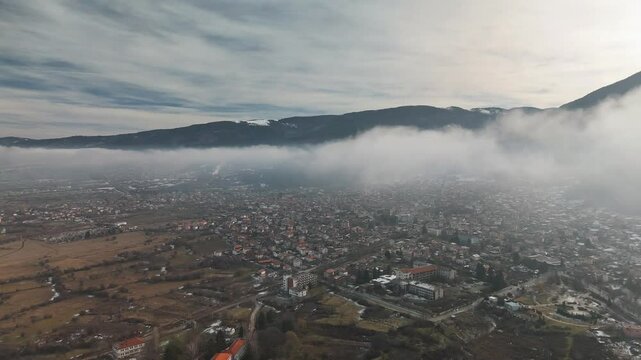 footage of a mist on Sapareva Banya Town on a sunny day in Bulgaria with mountain in the background