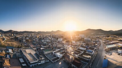 Fototapeta premium Sunrise Cityscape: A panoramic view of a vibrant town nestled amidst rolling hills, bathed in the golden glow of a breathtaking sunrise.