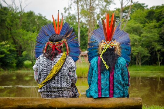 Sao Paulo, SP, Brazil - February 09 2020: Indigenous people, original people, sitting on a wooden bench on the riverbank details.