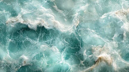 Obraz premium Birds-eye view of crystal-clear turquoise waters, with the frothy white foam of waves creating an abstract, dynamic pattern perfect for a natural textured background.