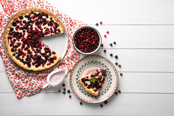Delicious currant pie and fresh berries on white wooden table