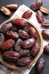 Tasty dried dates on black table, top view