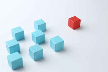 Red cube in front of blue ones on white background. Competition concept